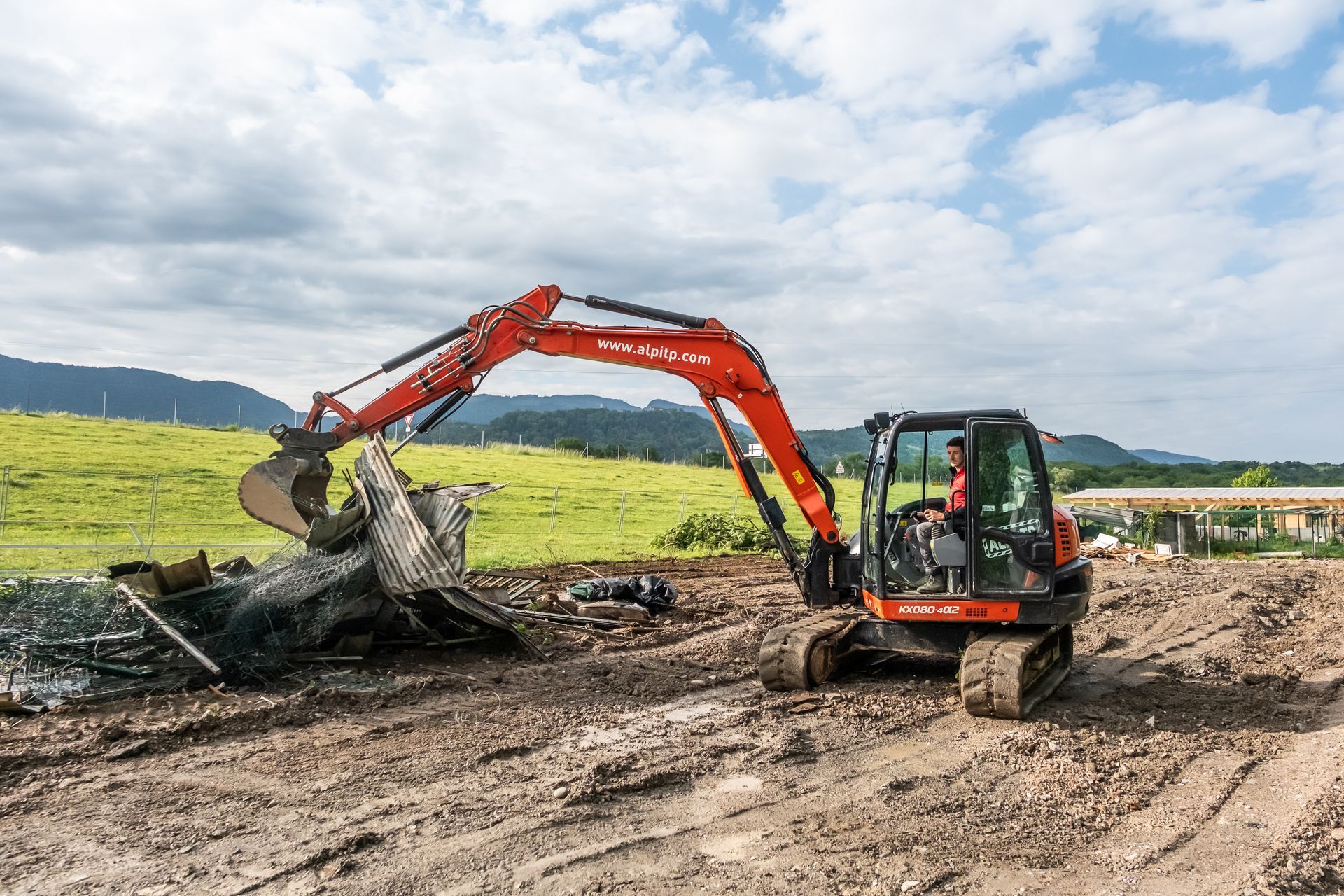 Tractopelle rouge sur un terrain.