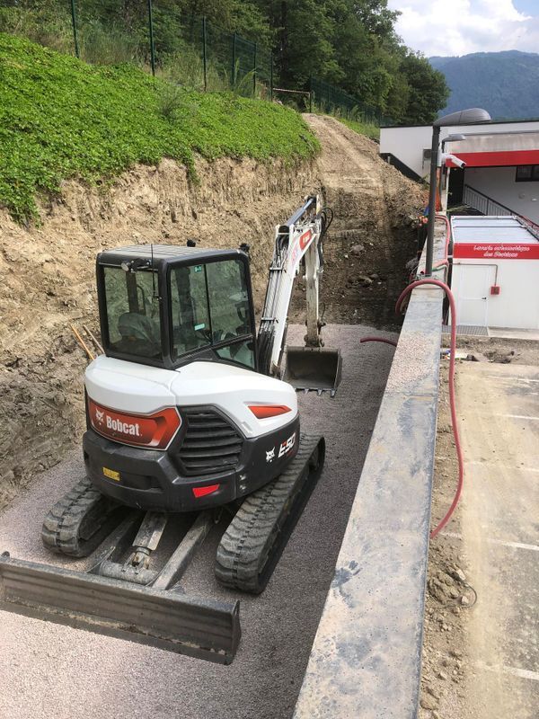 Tractopelle blanc et rouge sur un chantier.