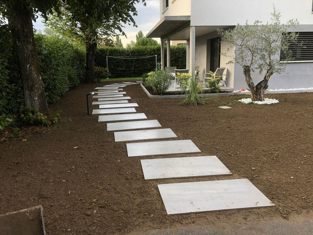 Chemin en dalles de béton dans le jardin d'une maison moderne.
