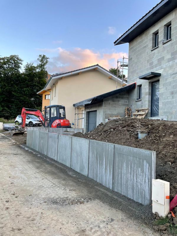 Mur en béton devant une habitation.