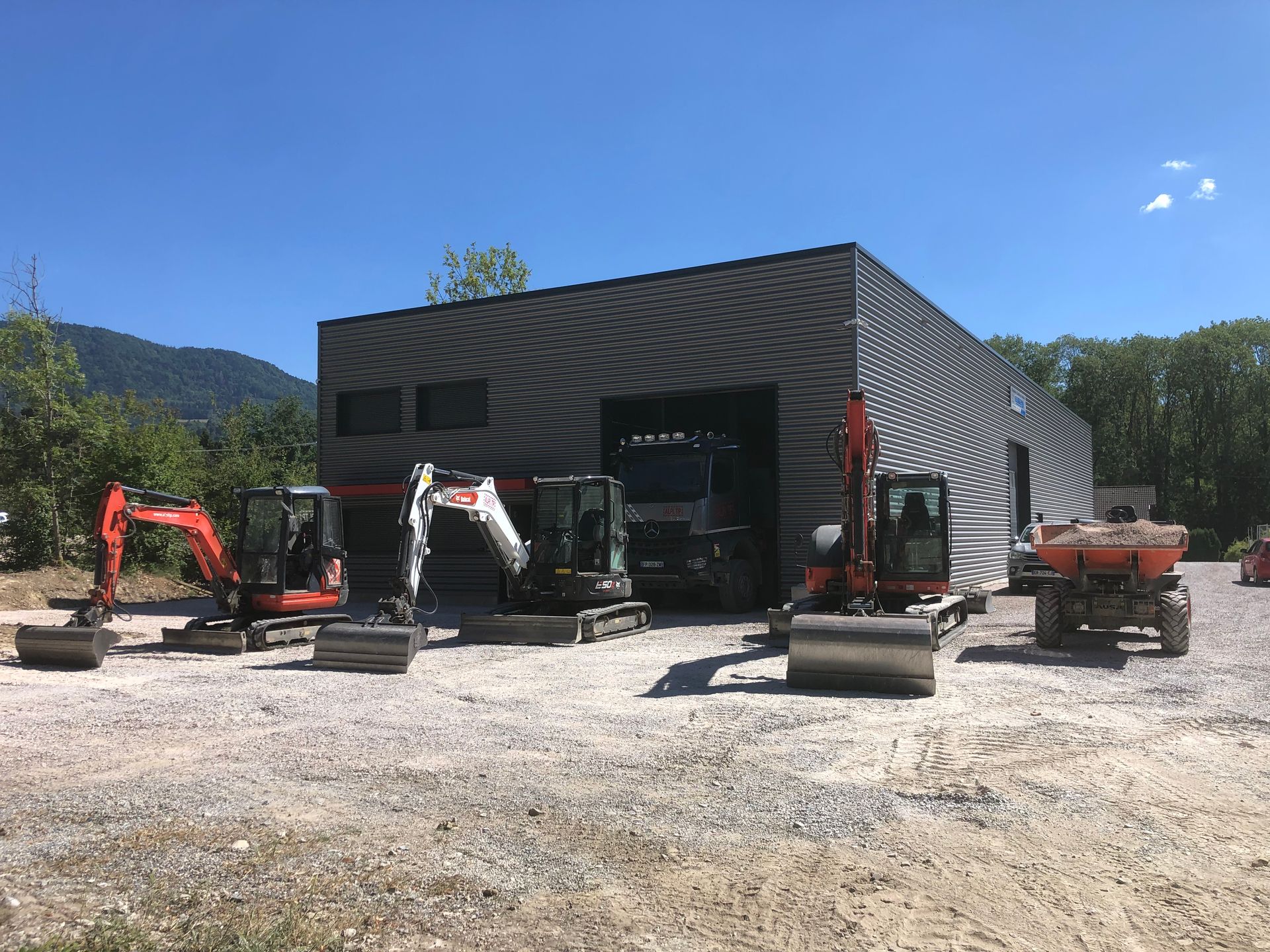 Bâtiment noir avec plusieurs engins de chantier.