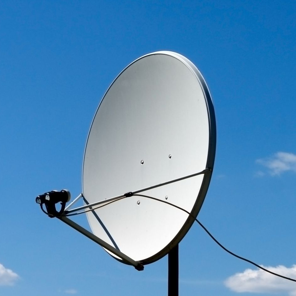 Antenne parabolique sur fond de ciel bleu.