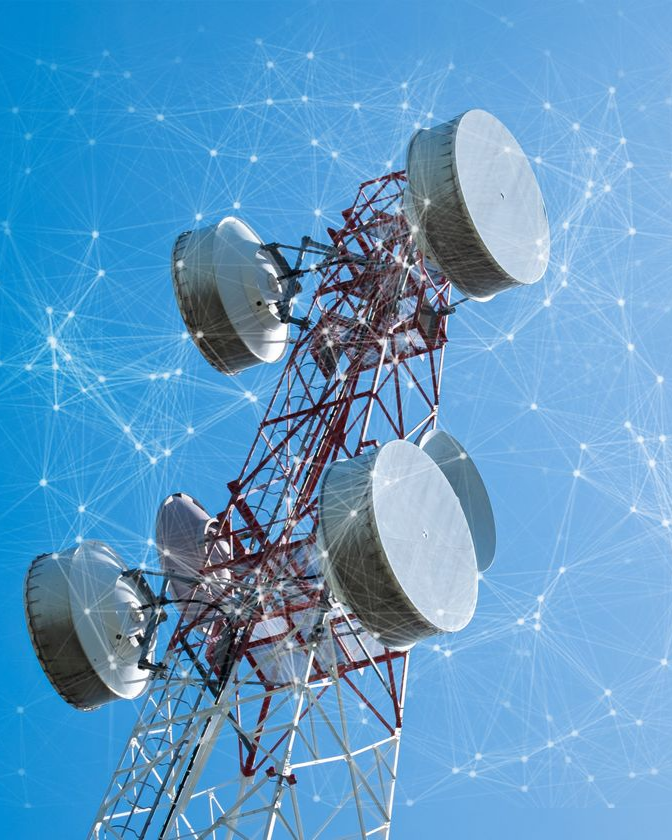 Tour de télécommunication avec de grandes antennes circulaires se détachant sur un ciel bleu avec un réseau superposé.
