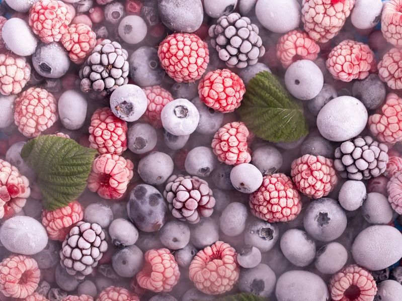 Una pila de bayas congeladas, incluidas frambuesas, arándanos y moras.