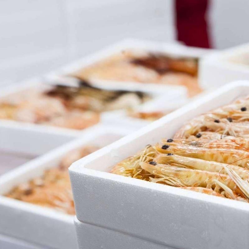 Un primer plano de una caja de camarones sobre una mesa.