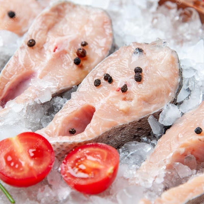 Un primer plano de un plato de pescado y tomates en hielo.