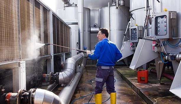 Employé tenant une perche pour du nettoyage à haute pression