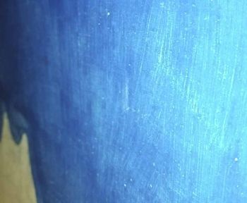 Superficie pintada de azul con pinceladas visibles y una veta más clara.