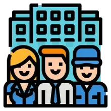 Tres personas sonrientes frente a un edificio de oficinas azul. El grupo incluye una mujer, un hombre de pelo naranja y un hombre con una gorra azul.