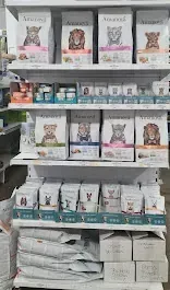 Un estante lleno de comida para perros en una tienda.