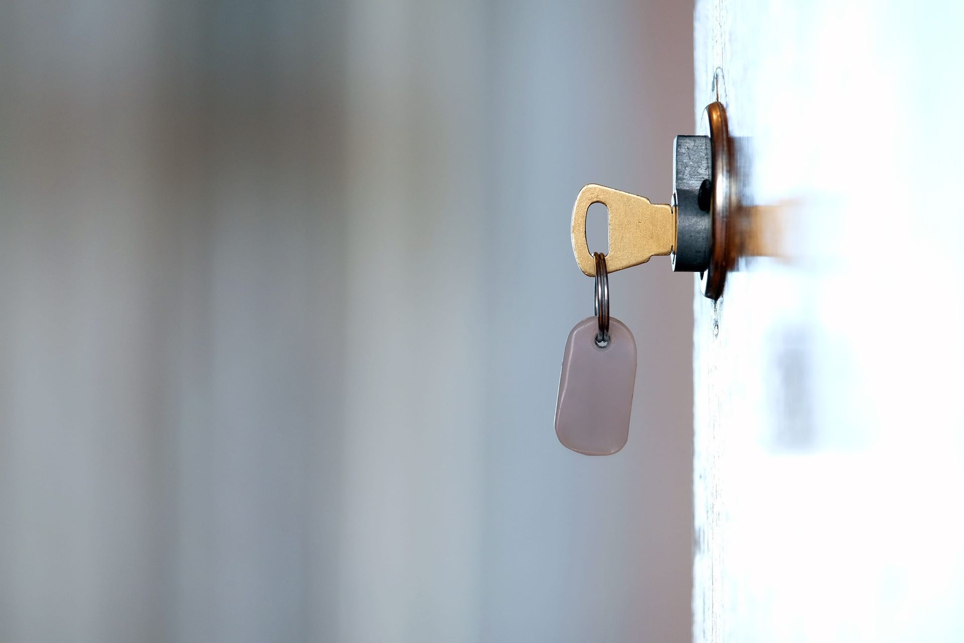 Llave en una cerradura de puerta con una etiqueta de llavero colgando de ella