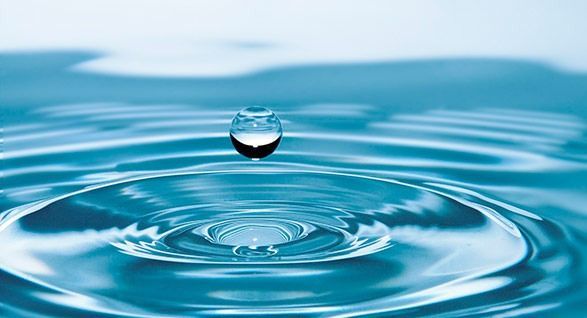 Una gota de agua está cayendo en un cuerpo de agua.