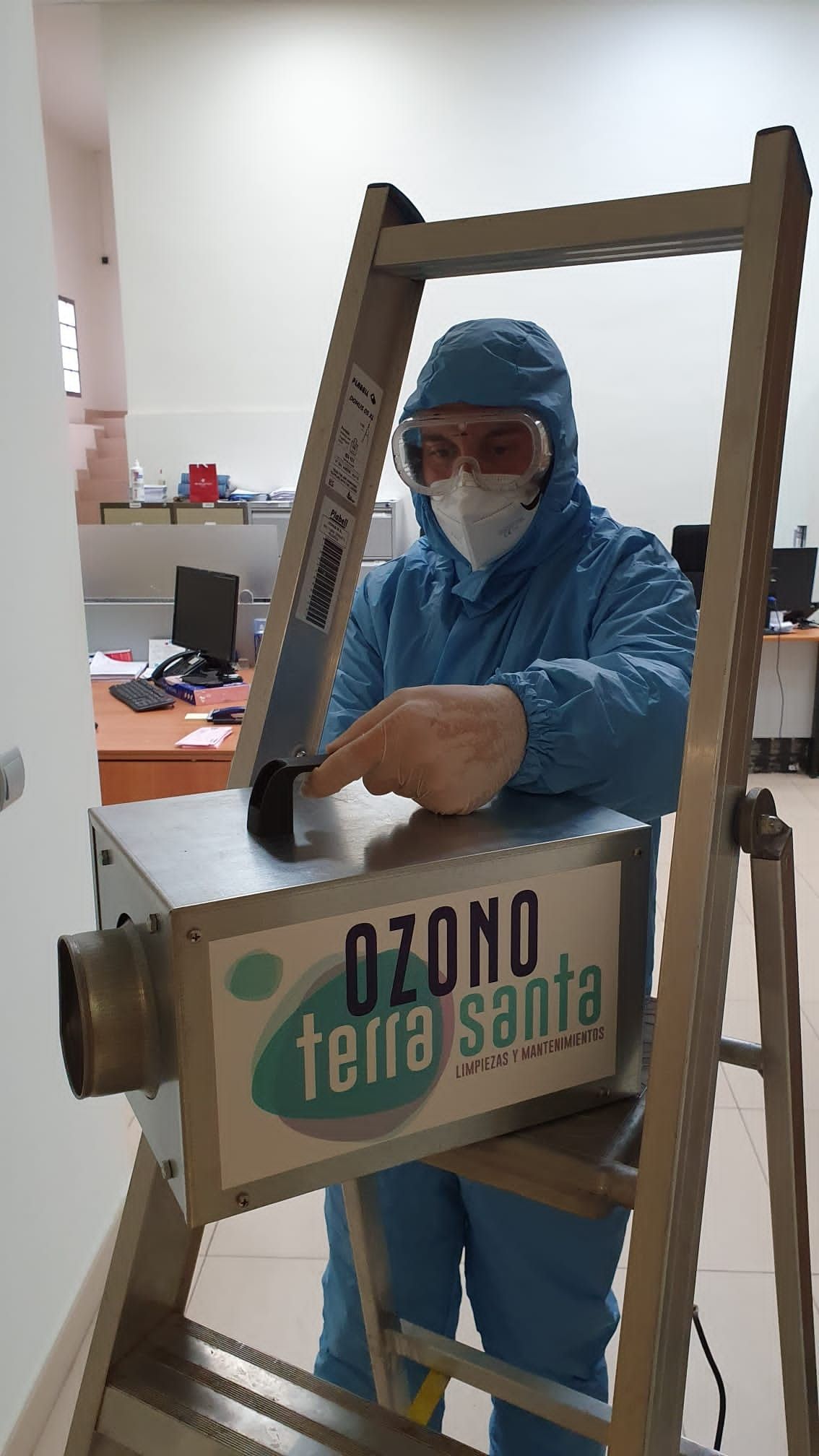 Un hombre con un traje de protección está de pie en una escalera.