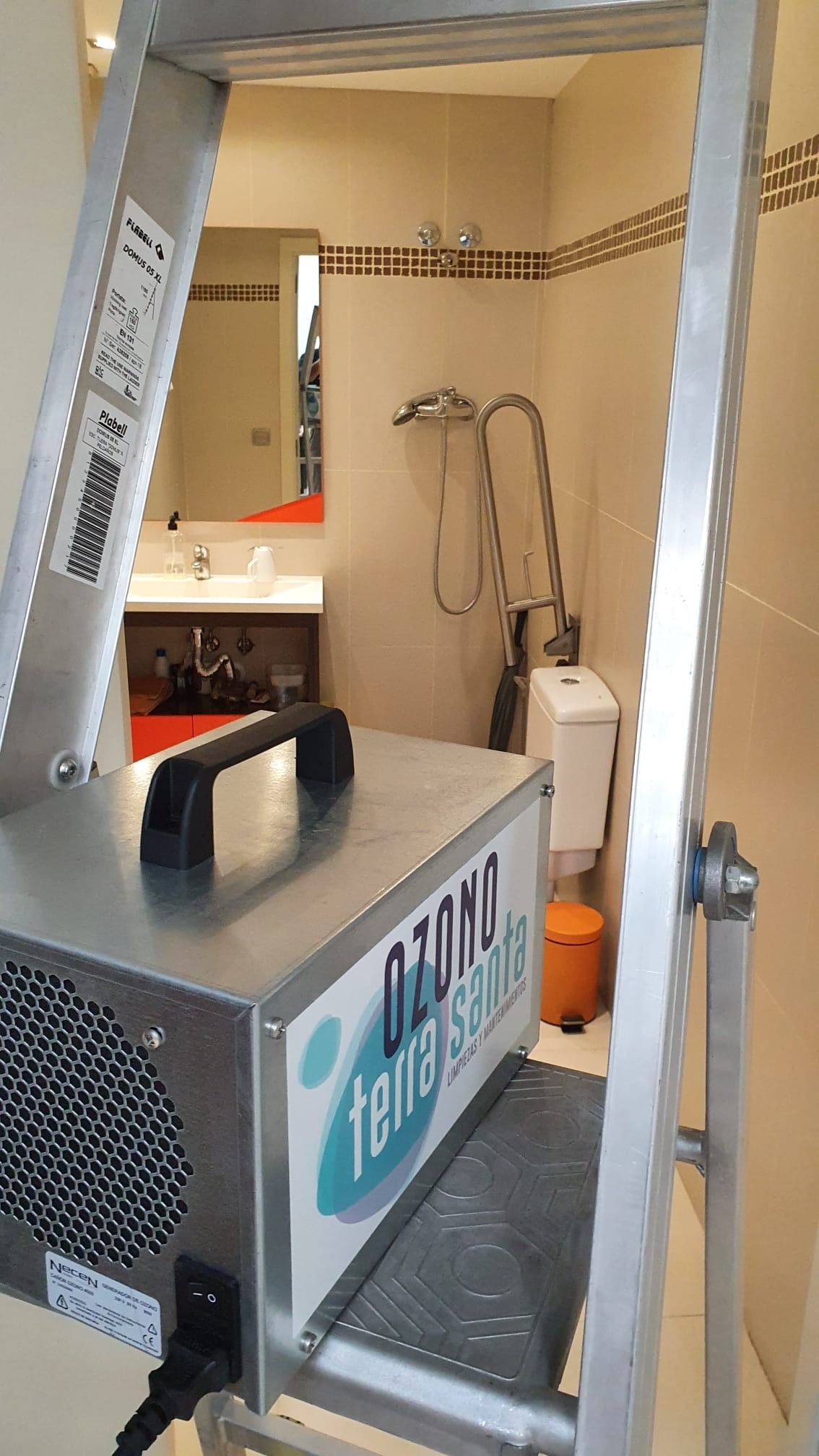 Una escalera está al lado de una máquina en un baño.