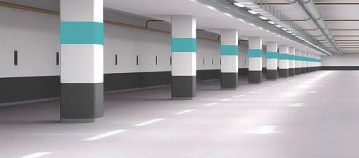 Un estacionamiento vacío con columnas pintadas de diferentes colores.