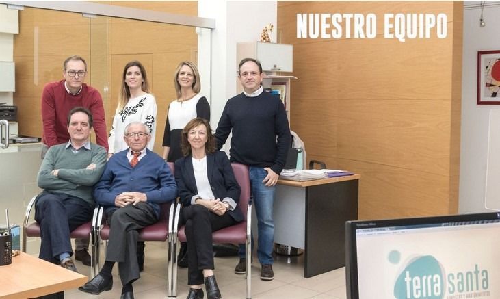 Un grupo de personas posa para una foto frente a un cartel que dice nuestro equipo.