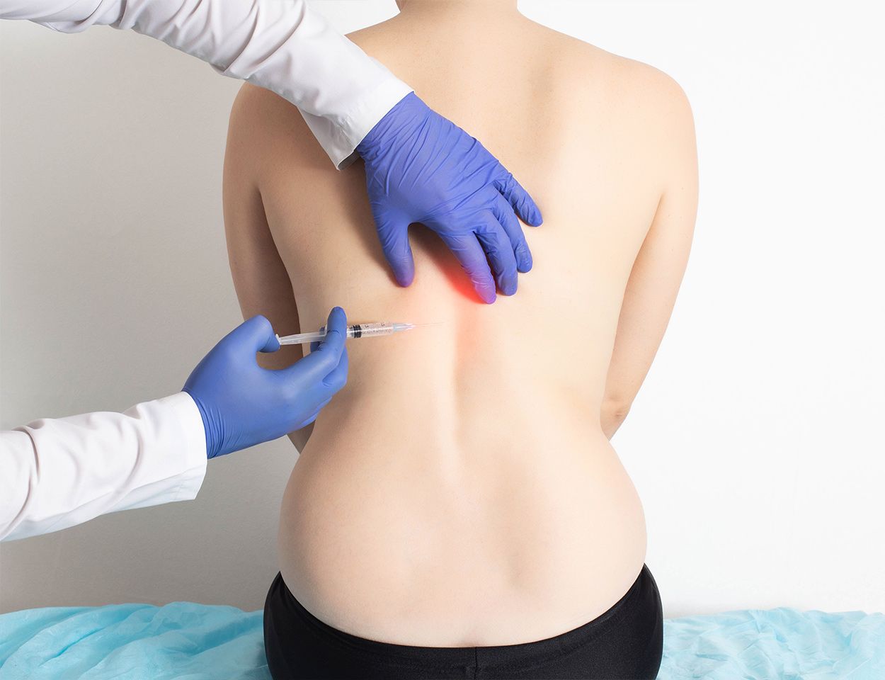 Mains gantée tenant une seringue