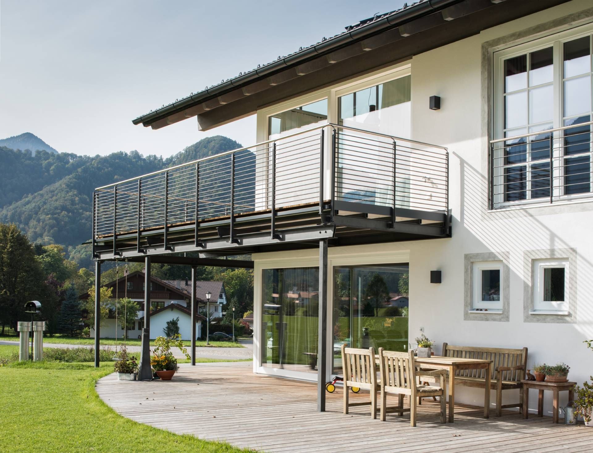 Weißes Haus mit dunklem Dach und großem Balkon