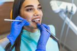 Una mujer con aparatos dentales saca la lengua.
