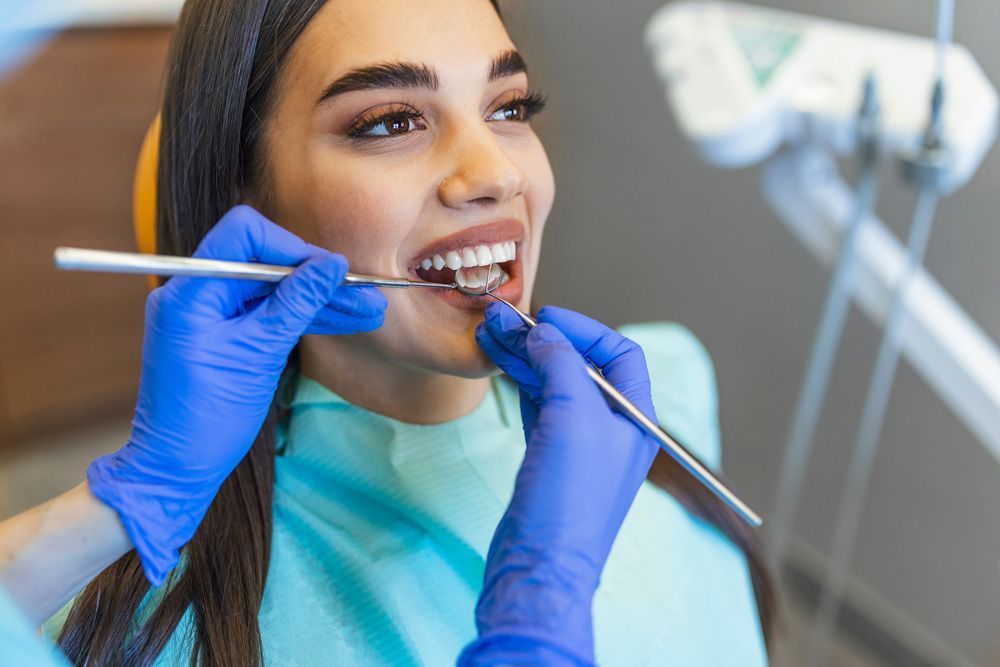 Una mujer está siendo examinada por un dentista.