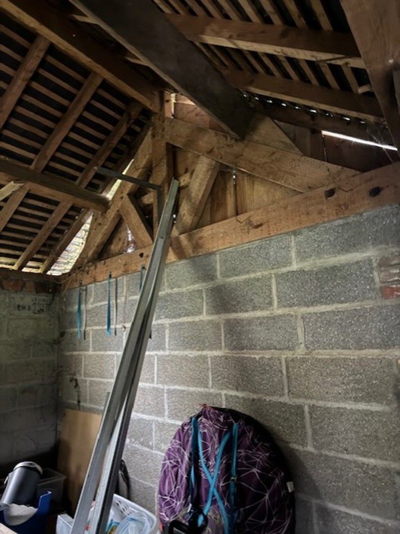 Un mur en parpaing sous une charpente en bois