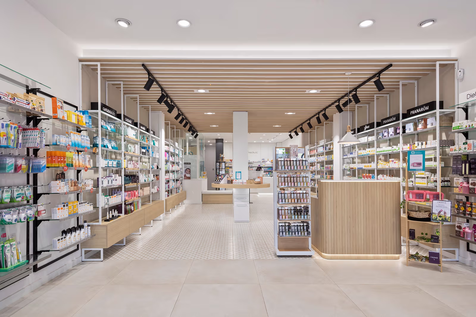 Interior de farmacia moderno con iluminación brillante, estanterías y mostrador de madera.