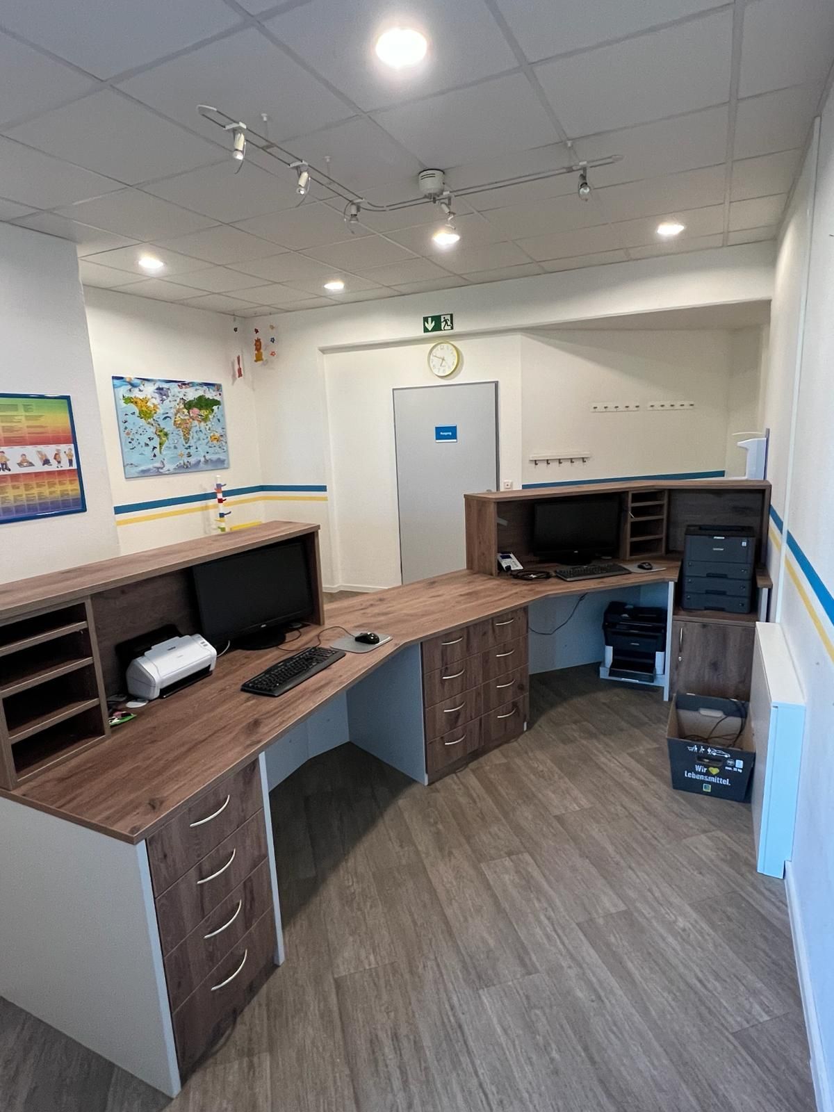 Ein Raum mit einem Schreibtisch, einem Computer, einem Drucker und einer Karte an der Wand | Tischlermeister DANIEL NETZ