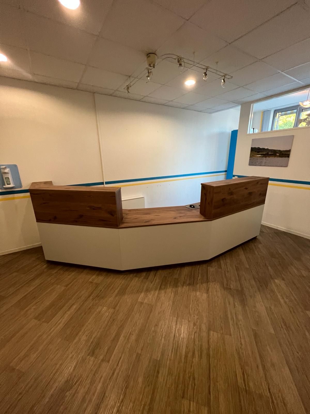 In der Mitte des Raumes steht eine Holztheke | Tischlermeister DANIEL NETZ