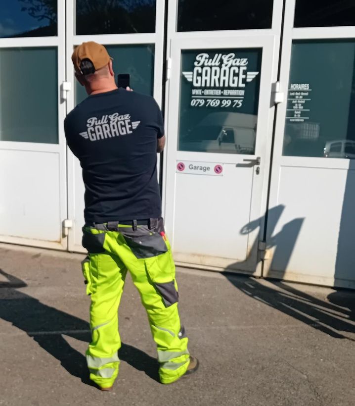 Un homme debout devant un garage plein d'essence