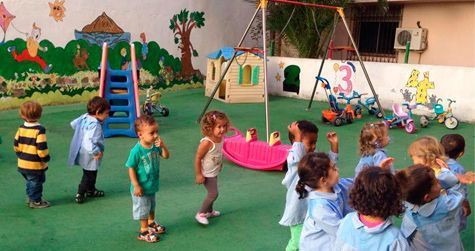 Un grupo de niños está parado en círculo en un patio de recreo.