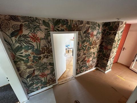 Ein Wohnraum mit einer Mustertapete an der Wand.