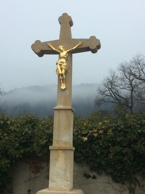 Ein Wegkreuz mit einem vergoldeten Christus.