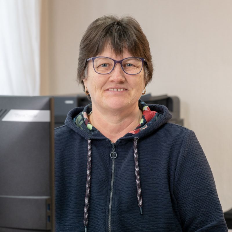 Eine Frau sitzt an einem Schreibtisch vor einem Computer.