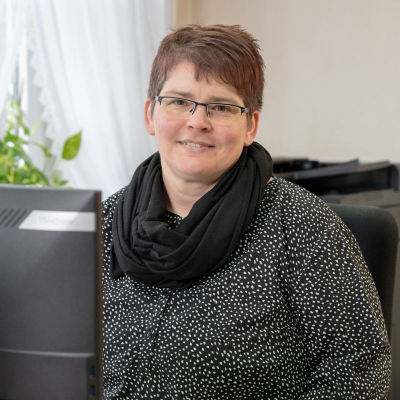 Eine Frau sitzt an einem Schreibtisch vor einem Computer.