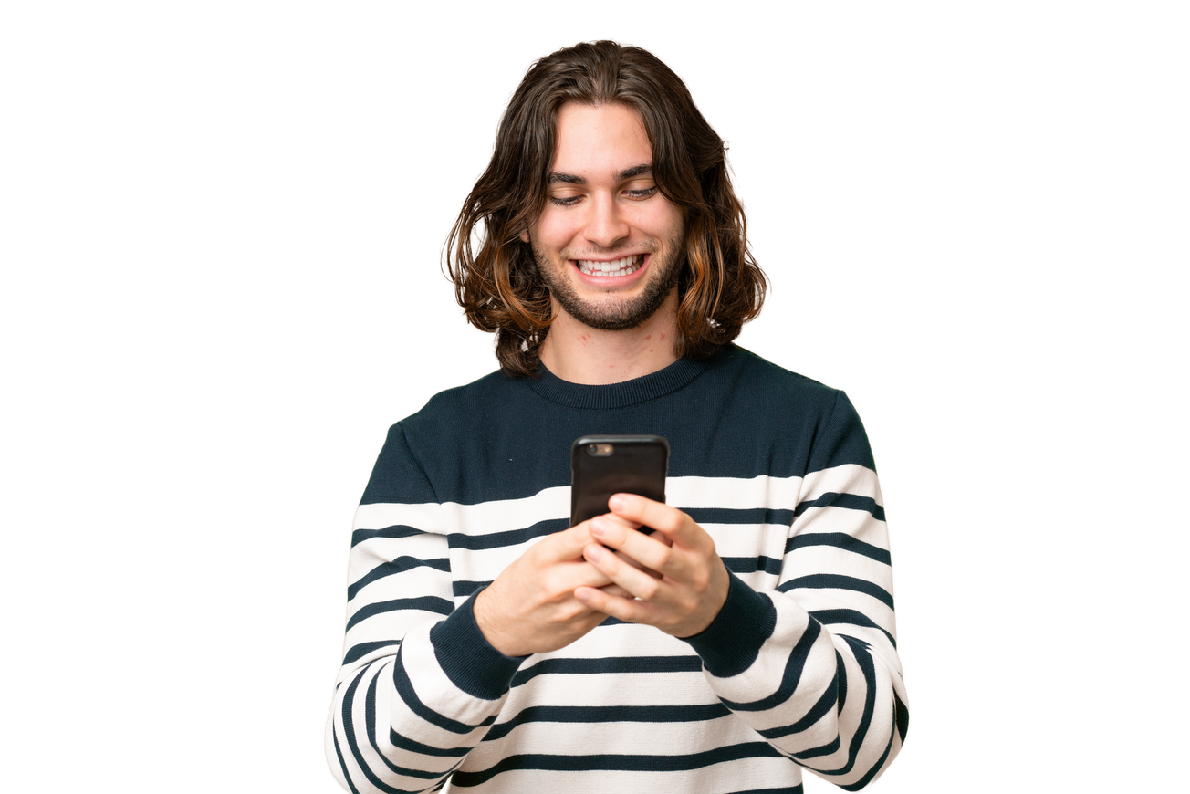 Une personne souriante en pull rayé regarde son téléphone sur fond blanc.