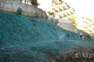 Dois homens com mangueiras a higienizar um espaço