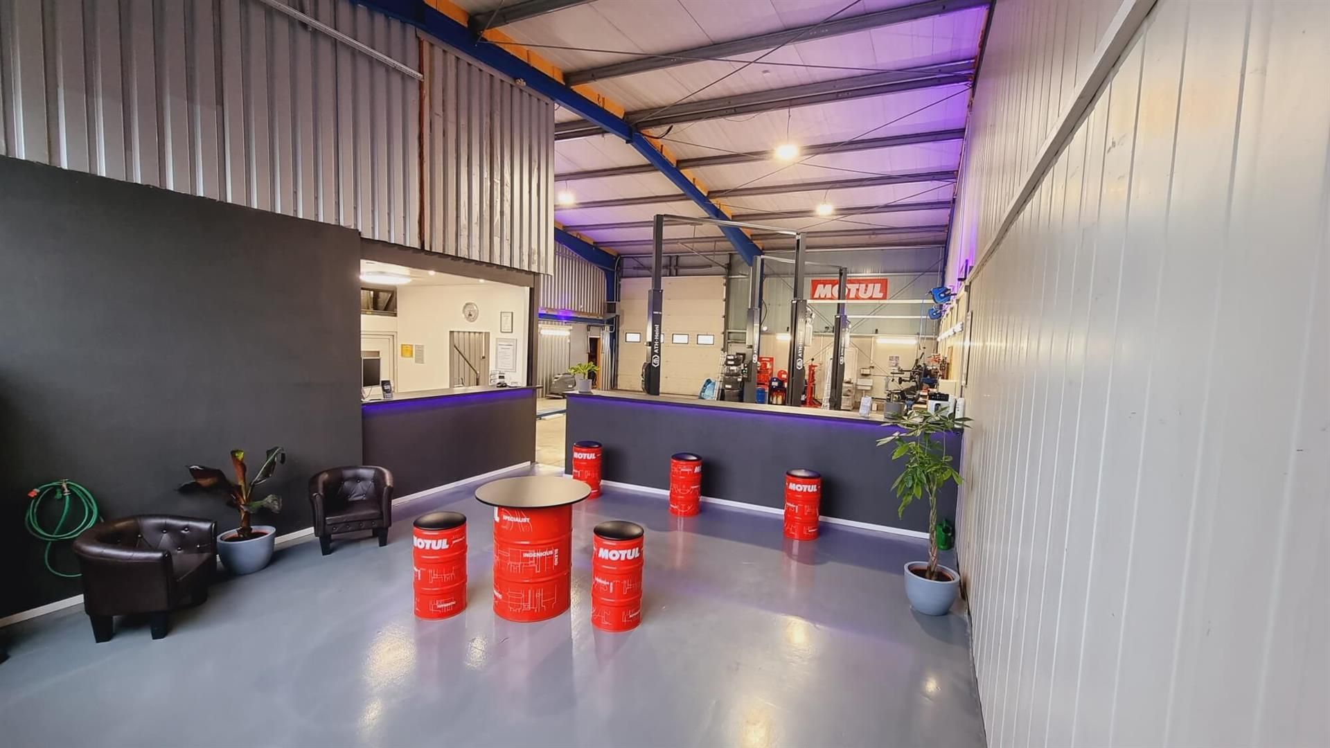 Ein Raum mit roten Fässern und einem Tisch darin