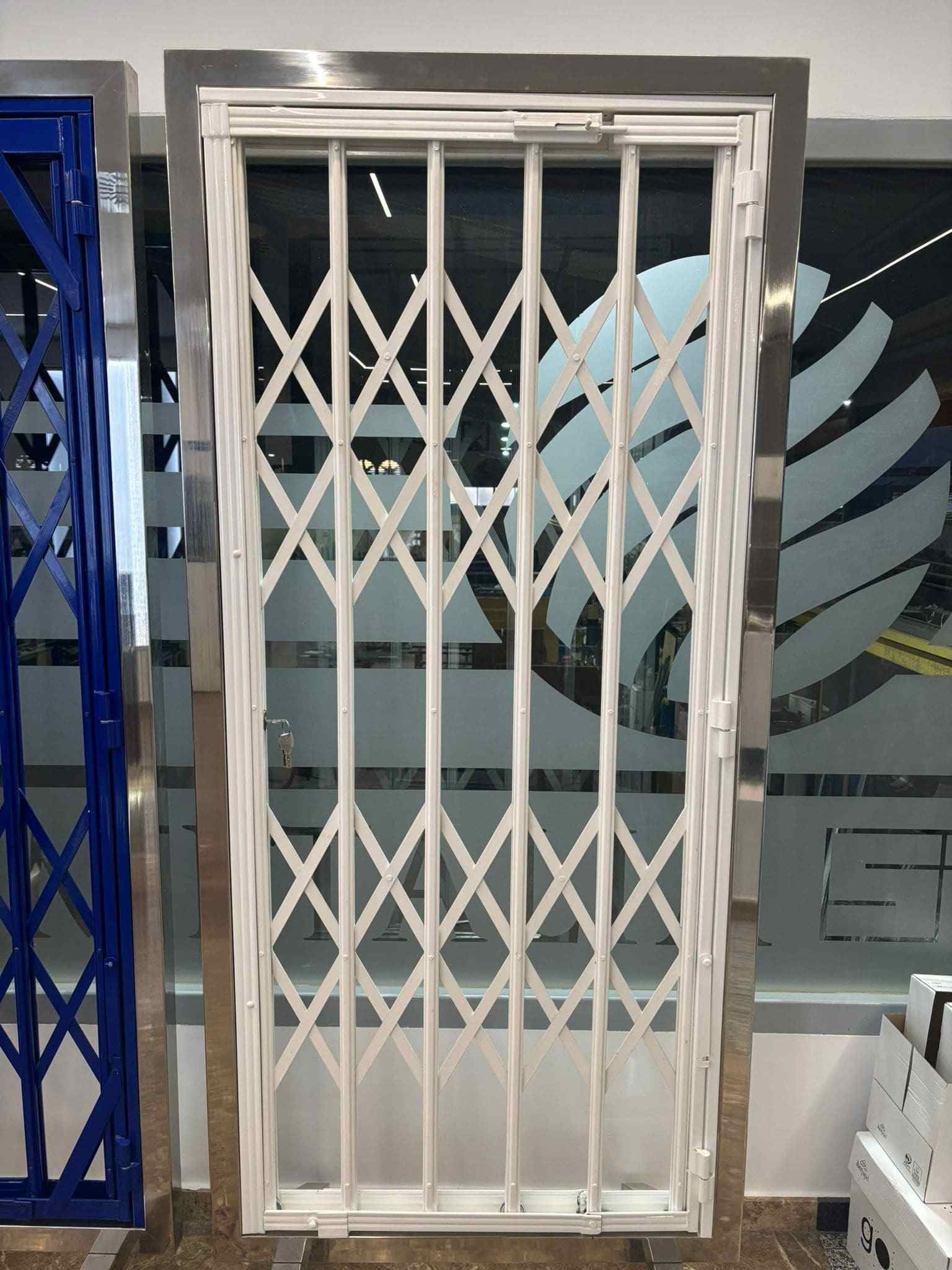 Una puerta blanca con marco de acero inoxidable se encuentra frente a una ventana.