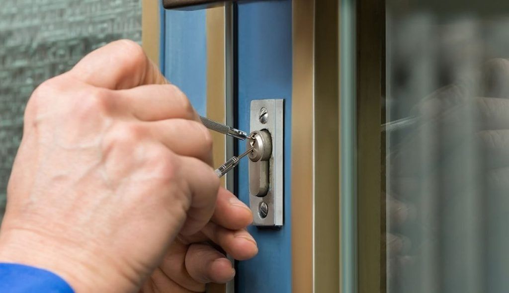 Una persona está abriendo una puerta con un destornillador.