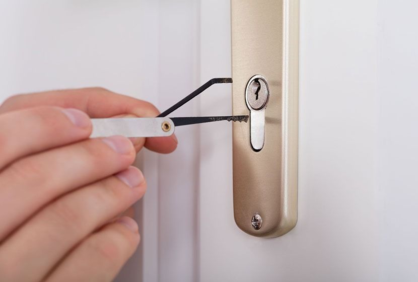 Una persona está usando un par de pinzas para abrir la cerradura de una puerta.