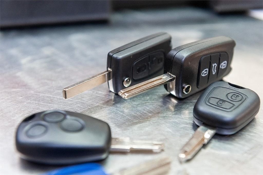 Hay tres llaves de coche sobre una mesa.