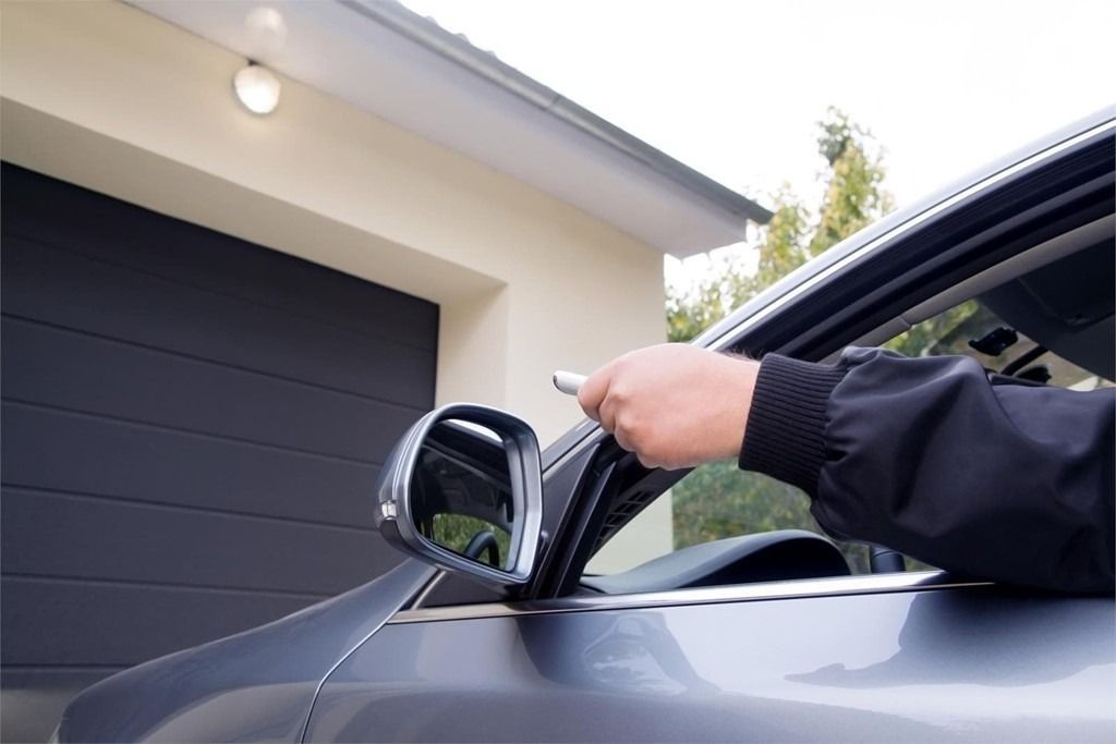 Una persona está usando un control remoto para abrir la puerta de un automóvil.