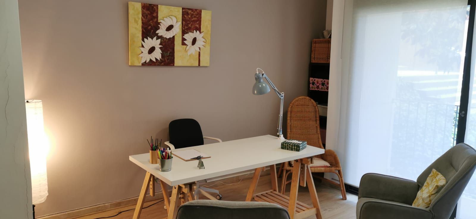 Un hombre está sentado en una silla hablando con una mujer acostada en un sofá.