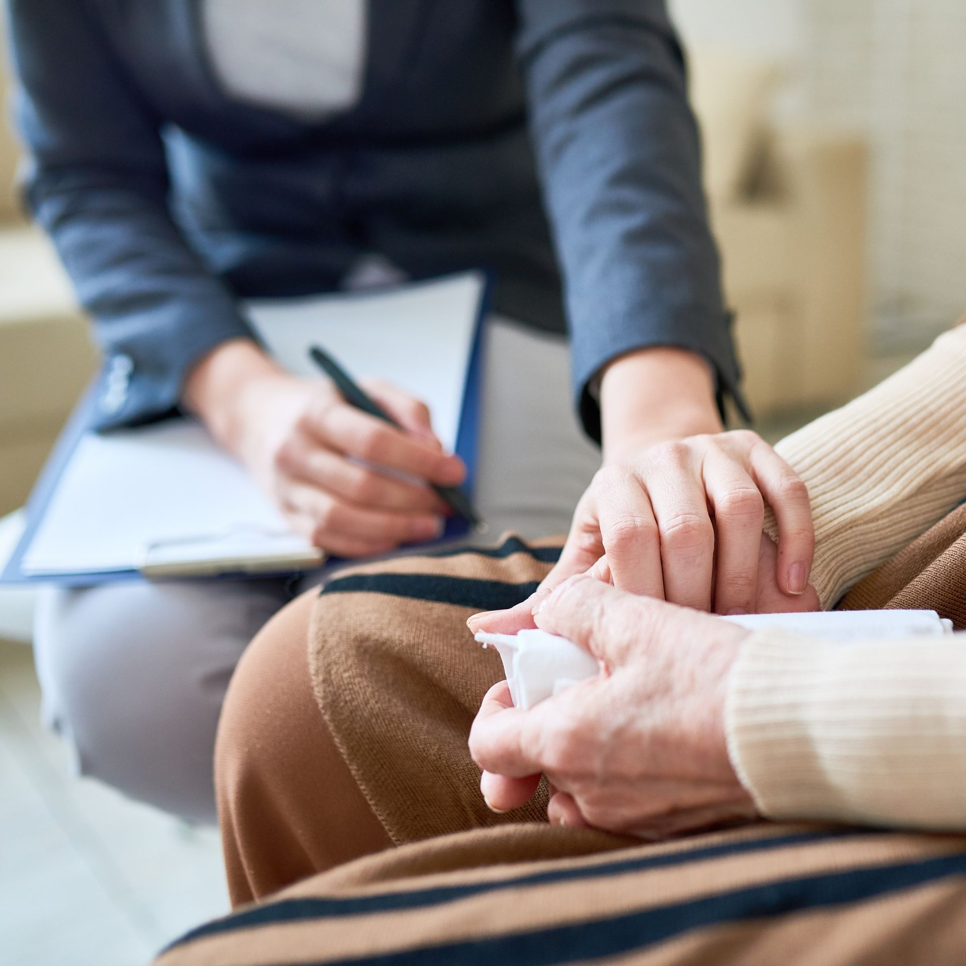 Una mujer sostiene la mano de otra mujer mientras está sentada en un sofá.