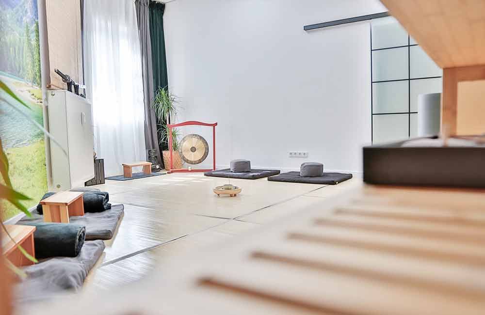 Ein Raum mit vielen Kissen und einem Gong auf dem Boden.