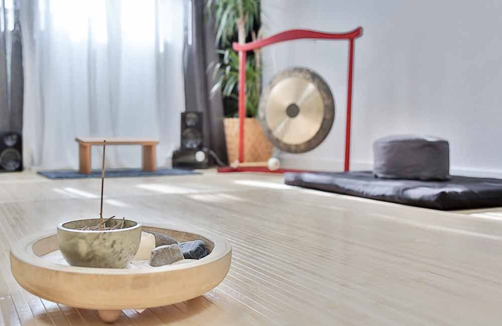 Ein Raum mit vielen Kissen und einem Gong auf dem Boden.