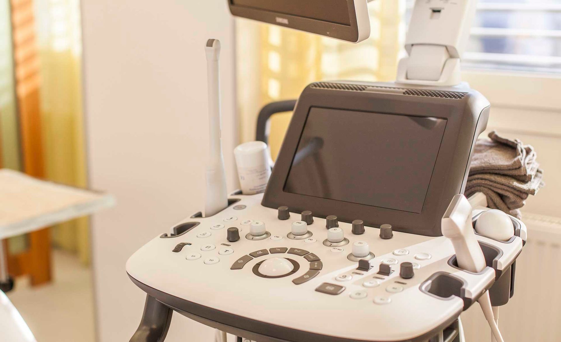 Ein Ultraschallgerät steht auf einem Tisch in einem Krankenhauszimmer.
