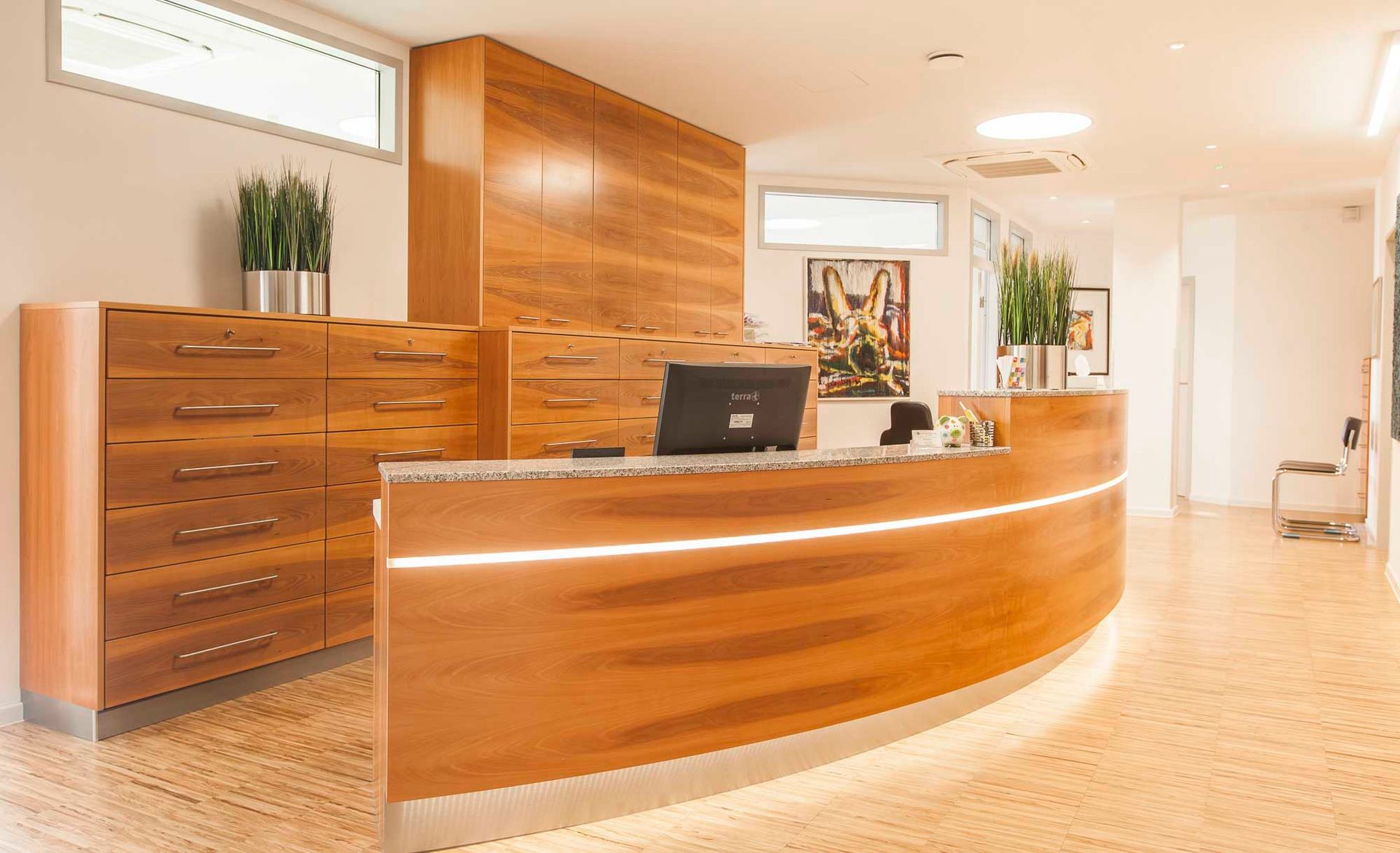 Ein hölzerner Empfangstresen in einem Krankenhaus mit einem Computer darauf.
