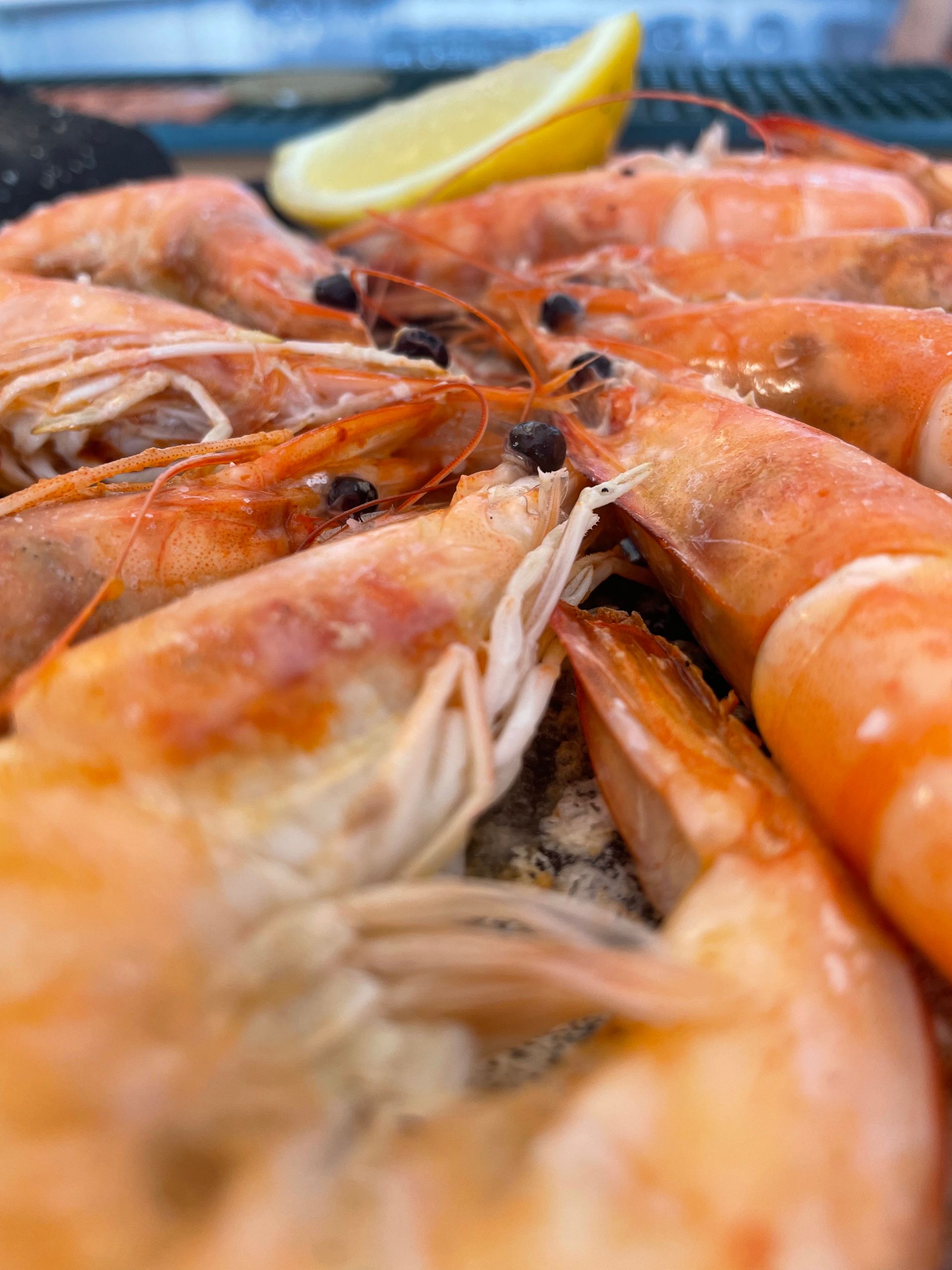 Un primer plano de un plato de camarones con una rodaja de limón.