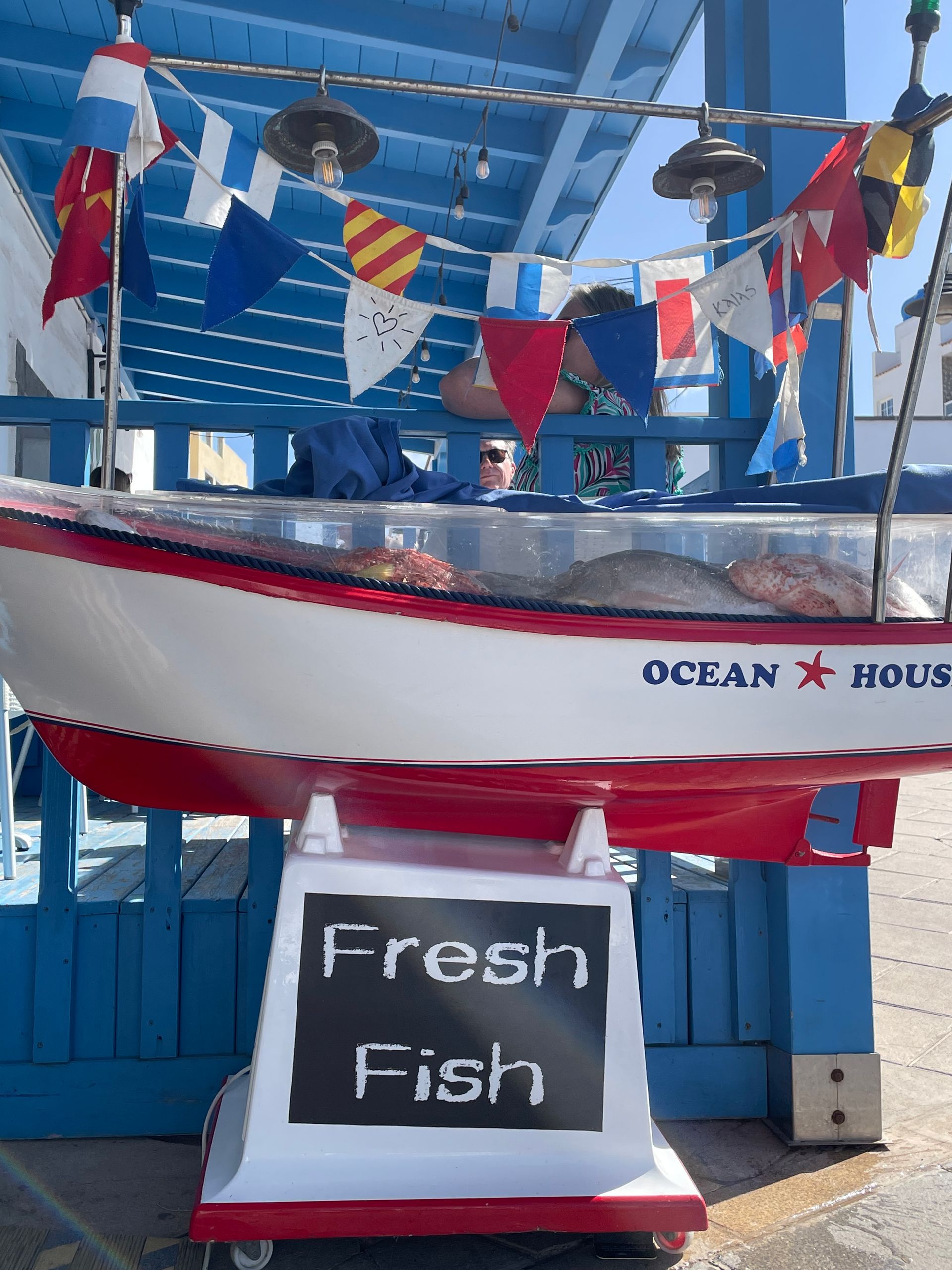 Un barco con un cartel que dice pescado fresco.